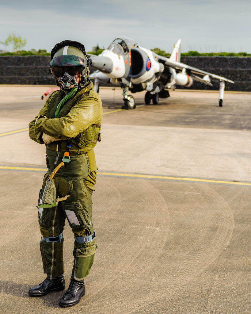 RAF re-enactor pilot standing in front of a Harrier GR3 at Cosford