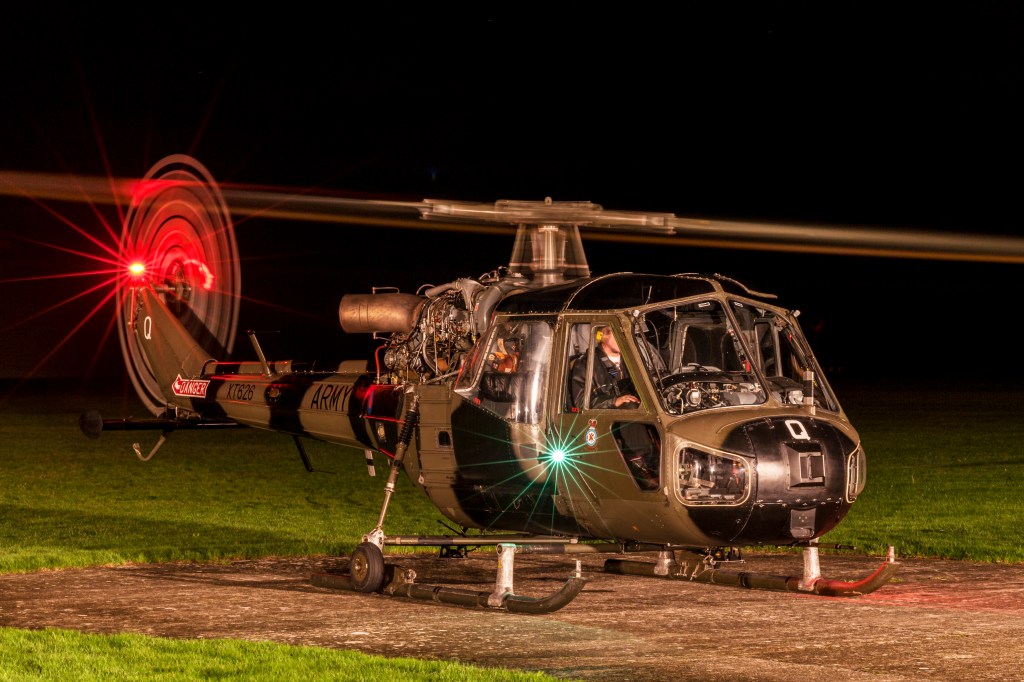 British Army Westland Scout helicopter XT826 idling at night with rotor light trails