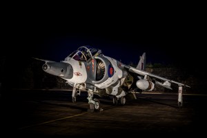 Hawker Siddeley Harrier jump jet parked under floodlight at night