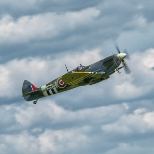 Supermarine Spitfire fighter banking hard against a cloudy sky