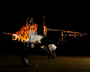 SEPECAT Jaguar in Tiger Meet livery with shark-mouth nose art, floodlit at night