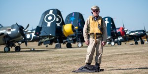WWII US Navy aircrew re-enactor standing in front of a line of Vought Corsair fighters