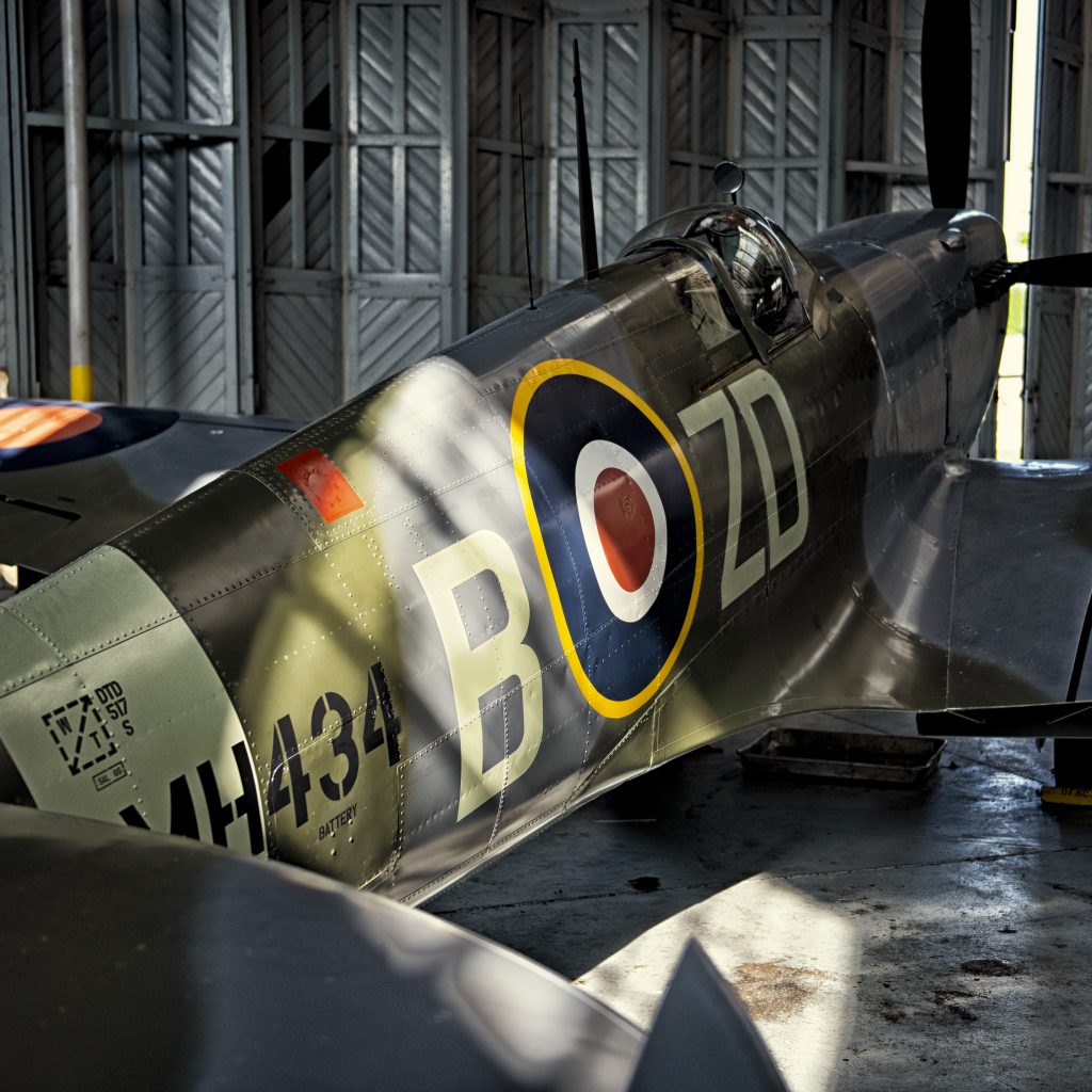 Supermarine Spitfire MH434 in 222 Squadron colours (ZD-B) catching the sunlight in a hangar at IWM Duxford