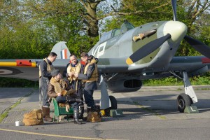 Reenactors in RAF flying kit gathered by the nose of Hawker Hurricane BE505 at North Weald