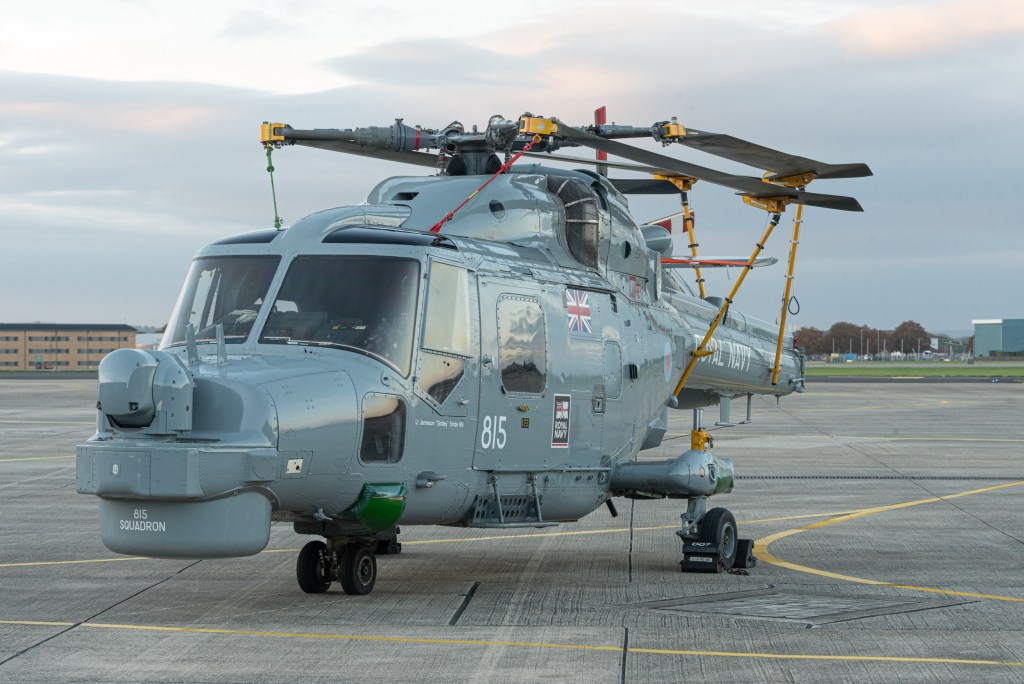 Westland Lynx XZ736 in Royal Navy grey on the apron at RNAS Yeovilton at dusk with its rotor blades folded.