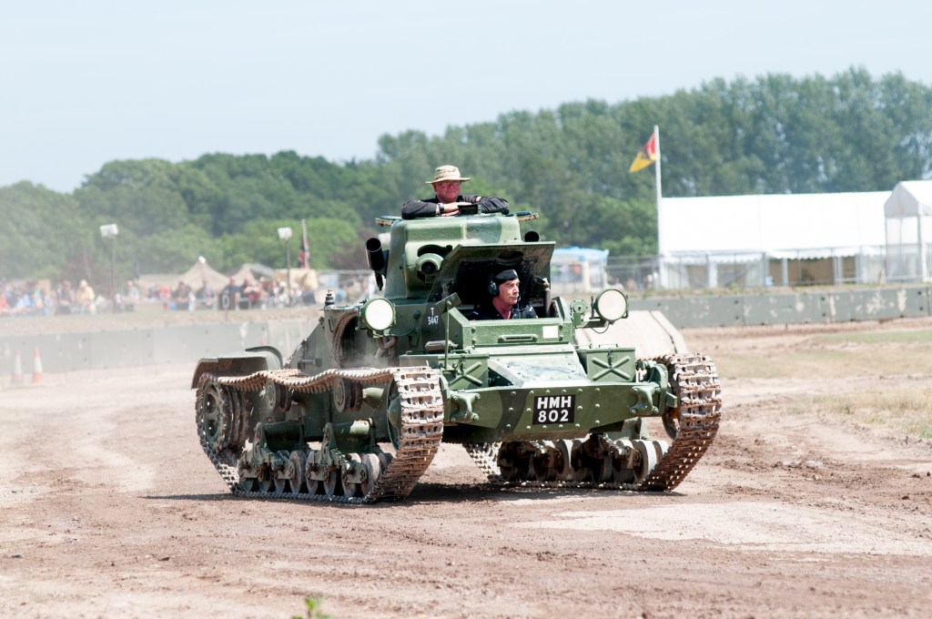 Matilda I infantry tank with the registration plate HMH 802 and a crew of two driving across the arena at Tankfest, Bovington