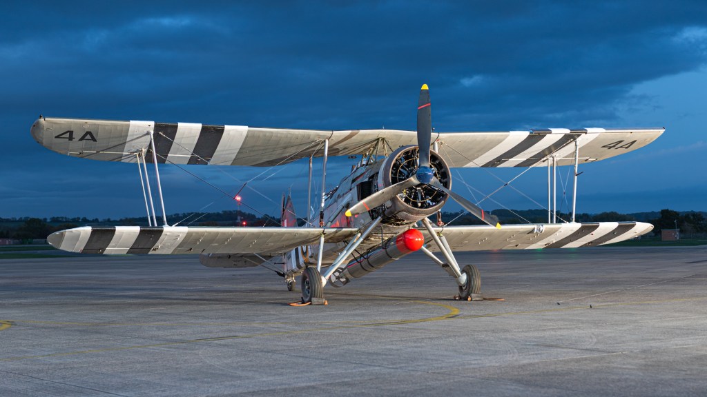 Head-on view of Swordfish W5856 in deep blue twilight with a red-nosed torpedo beneath the fuselage